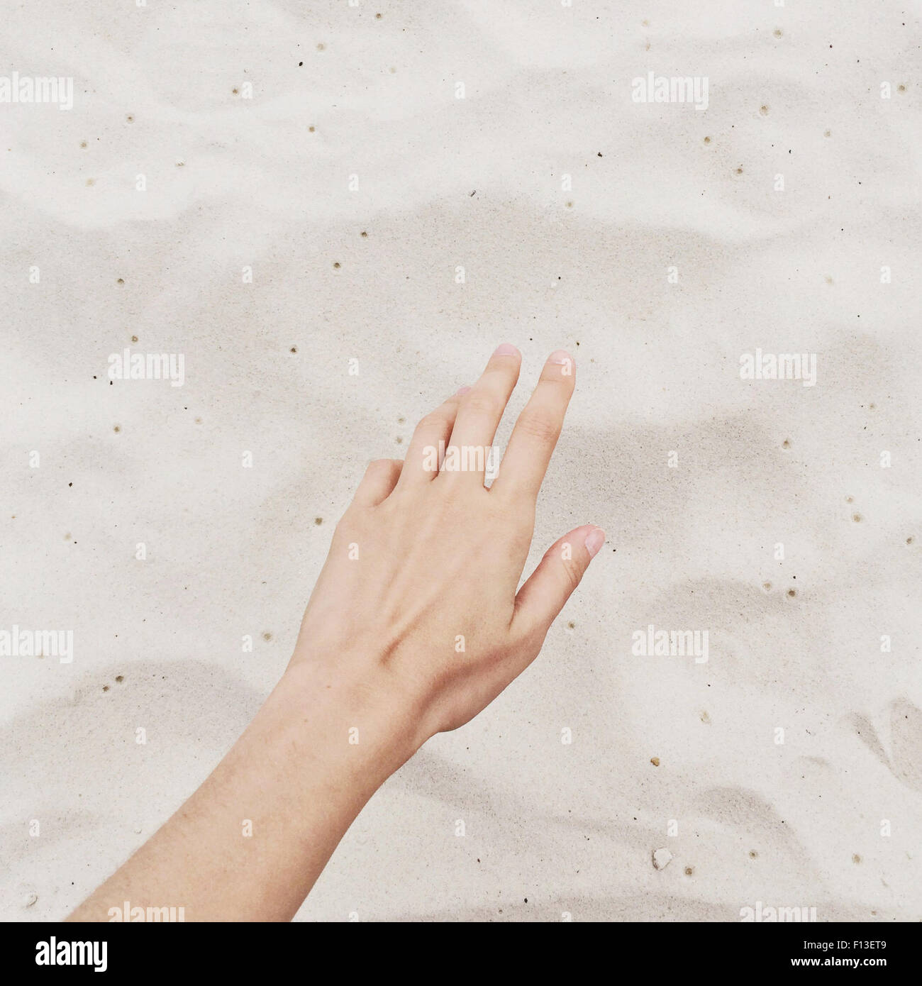 Nahaufnahme der Hand Griff nach Sand am Strand Stockfoto