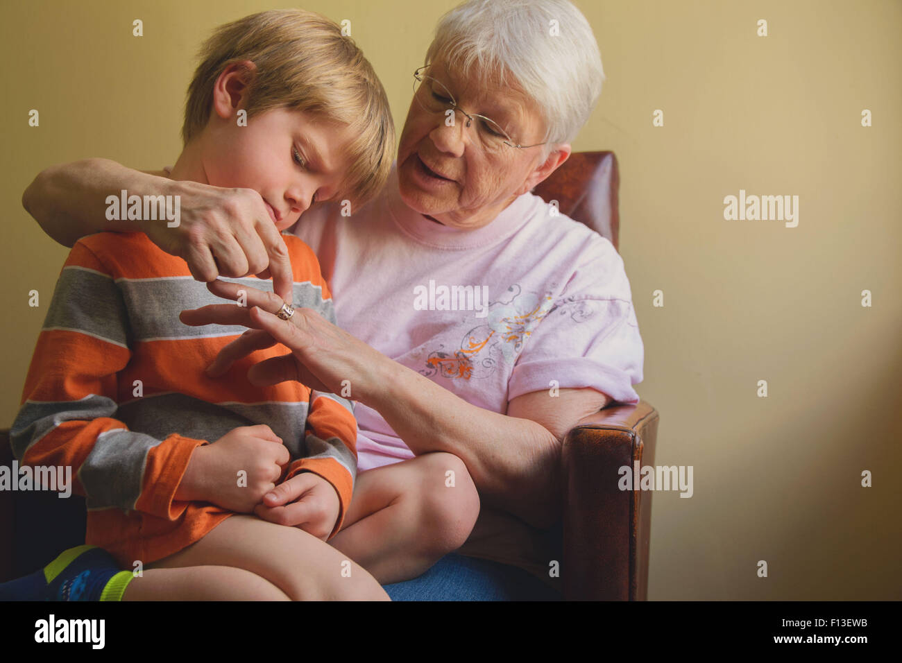Junge sitzt auf seiner Großmutter Schoß Stockfoto