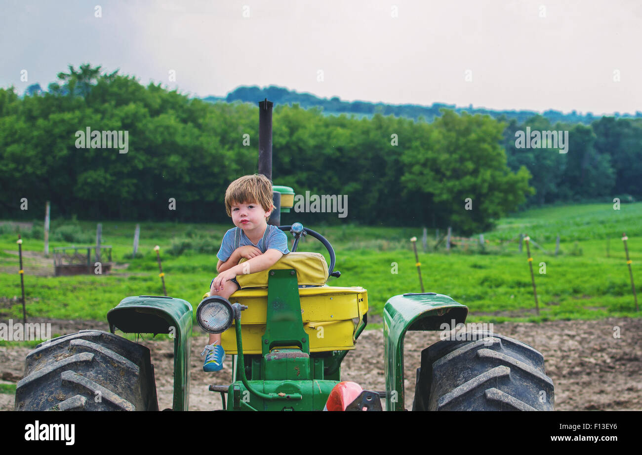 Bildnis eines Knaben sitzen auf einem Traktor Stockfoto