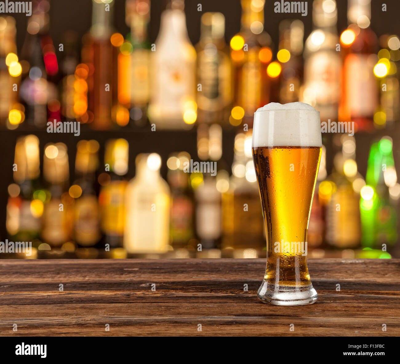 Glas helles Bier mit Bar im Hintergrund Stockfoto