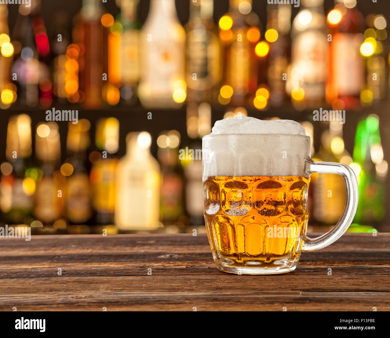 Glas helles Bier mit Bar im Hintergrund Stockfoto