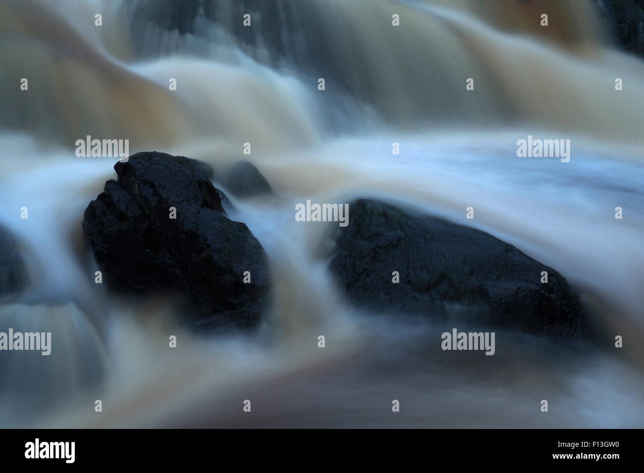 Spritzwasser zwischen Steinen im Wasserfall Stockfoto