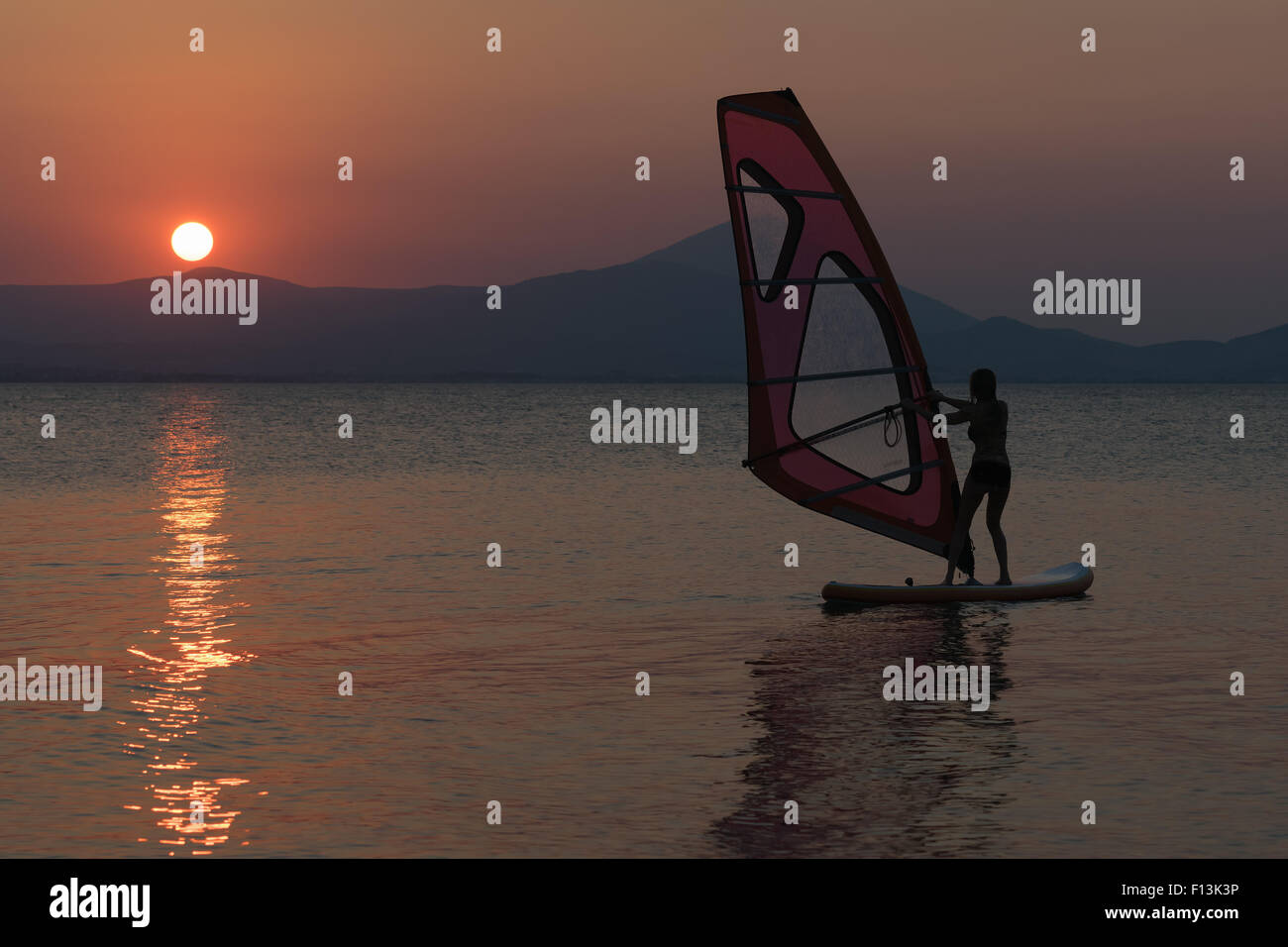 Schöner Surfen Frauen-Silhouette gegen den Sonnenuntergang als Hintergrund. Stockfoto