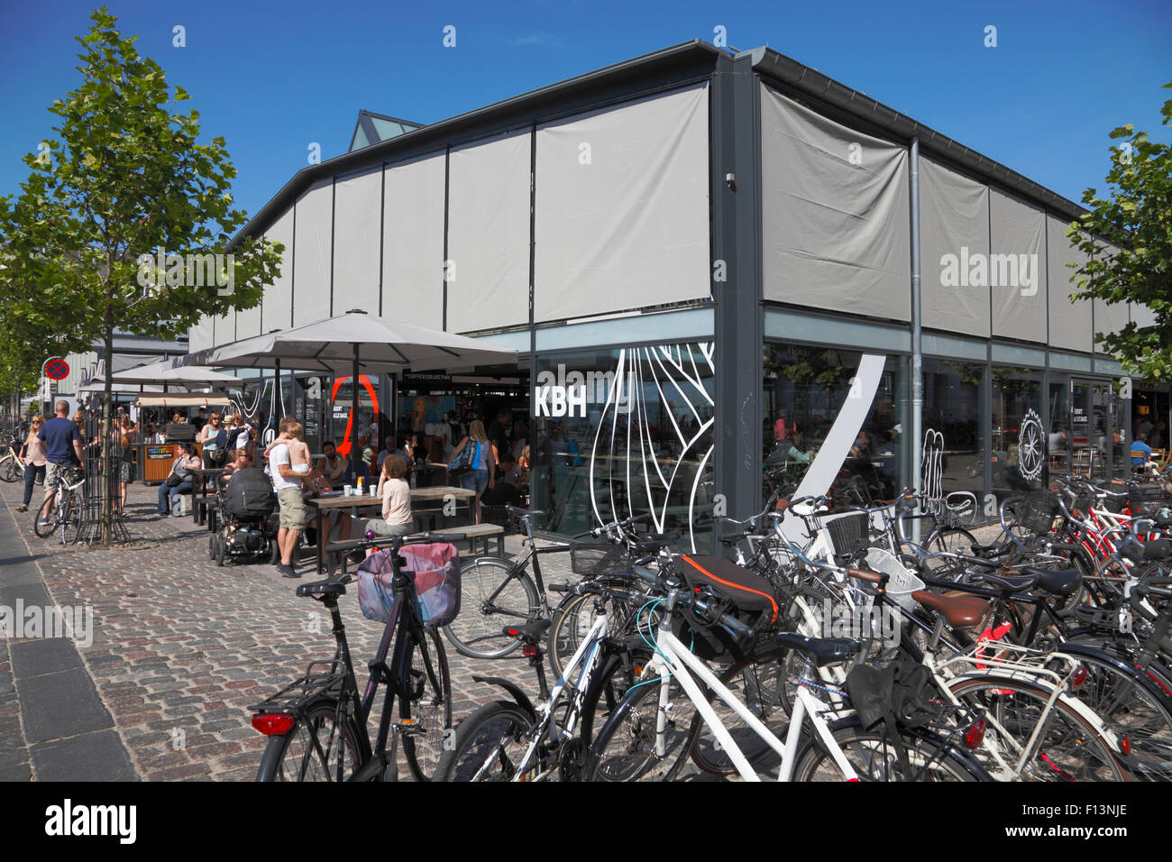 Torvehallerne, der überdachte Lebensmittelmarkt am Israels Plads in Kopenhagen an einem sonnigen Sommertag Samstag Morgen. Sonnenschirme nach unten. Stockfoto