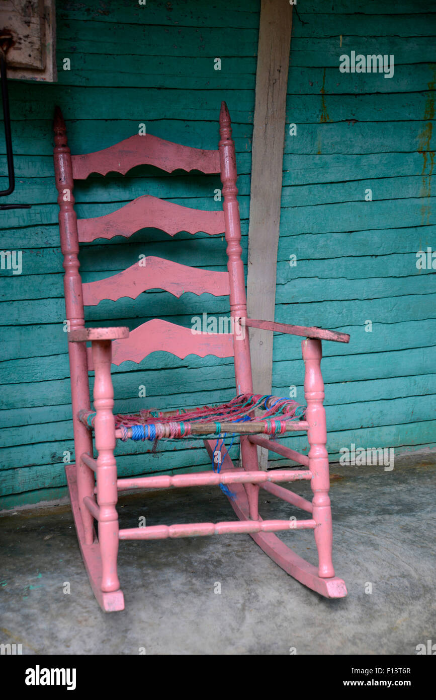 eine alte rosa aus Holz Schaukelstuhl sitzt auf einer Veranda Stockfoto