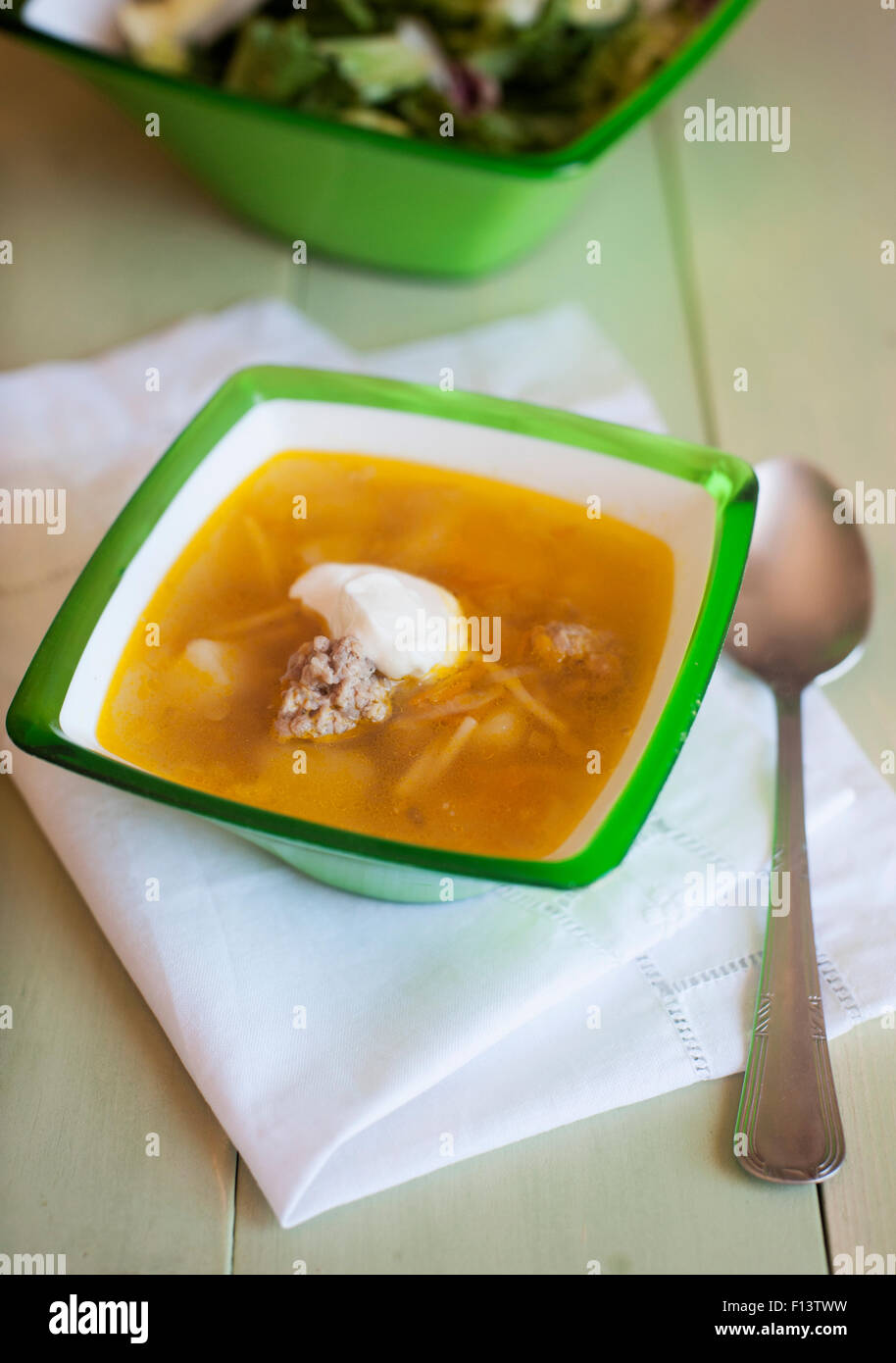 Suppe mit Hackfleischbällchen und Salat auf einem hölzernen Hintergrund Stockfoto