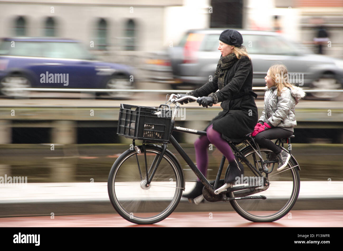 Eine Mutter mit ihrer Tochter mit dem Fahrrad in Amsterdam. Stockfoto