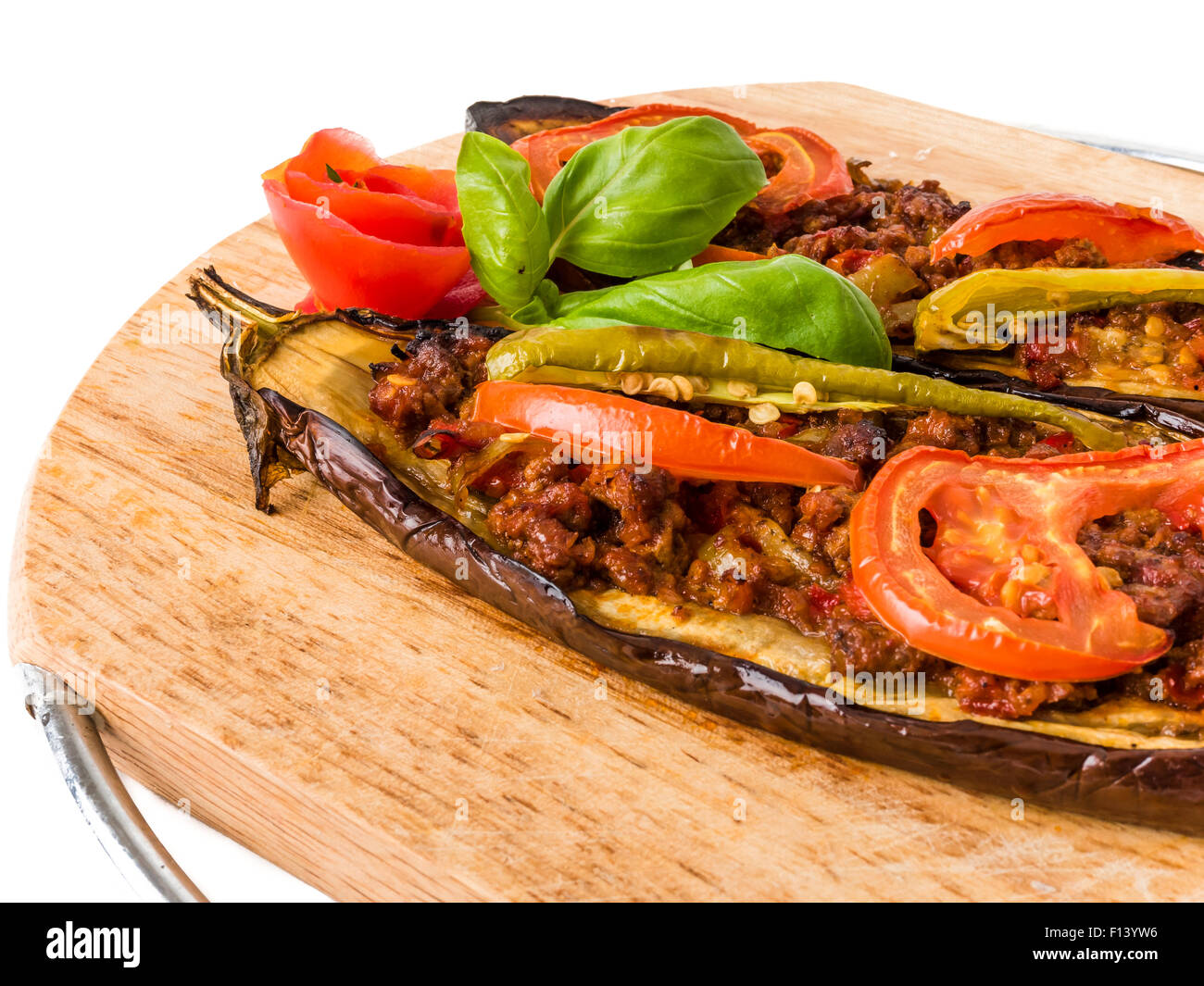 Schließen Sie eine hölzerne Schüssel mit zwei Hälften eine gefüllte Auberginen mediterrane Meze isoliert auf weißem Hintergrund. Stockfoto