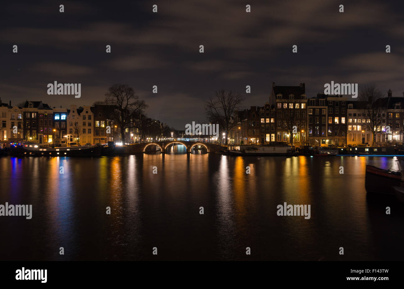 beleuchtete Amsterdam Canal und Bridge bei Nacht Stockfoto