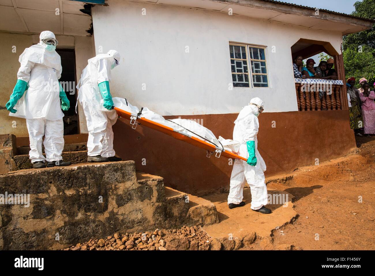 International Federation of Red Cross Freiwilligen Bestattung Teams entfernen den Körper eines Opfers Ebola aus einem Haus vor der Einnahme von ihnen für die Bestattung 24. Dezember 2014 in Freetown, Sierra Leone. Stockfoto
