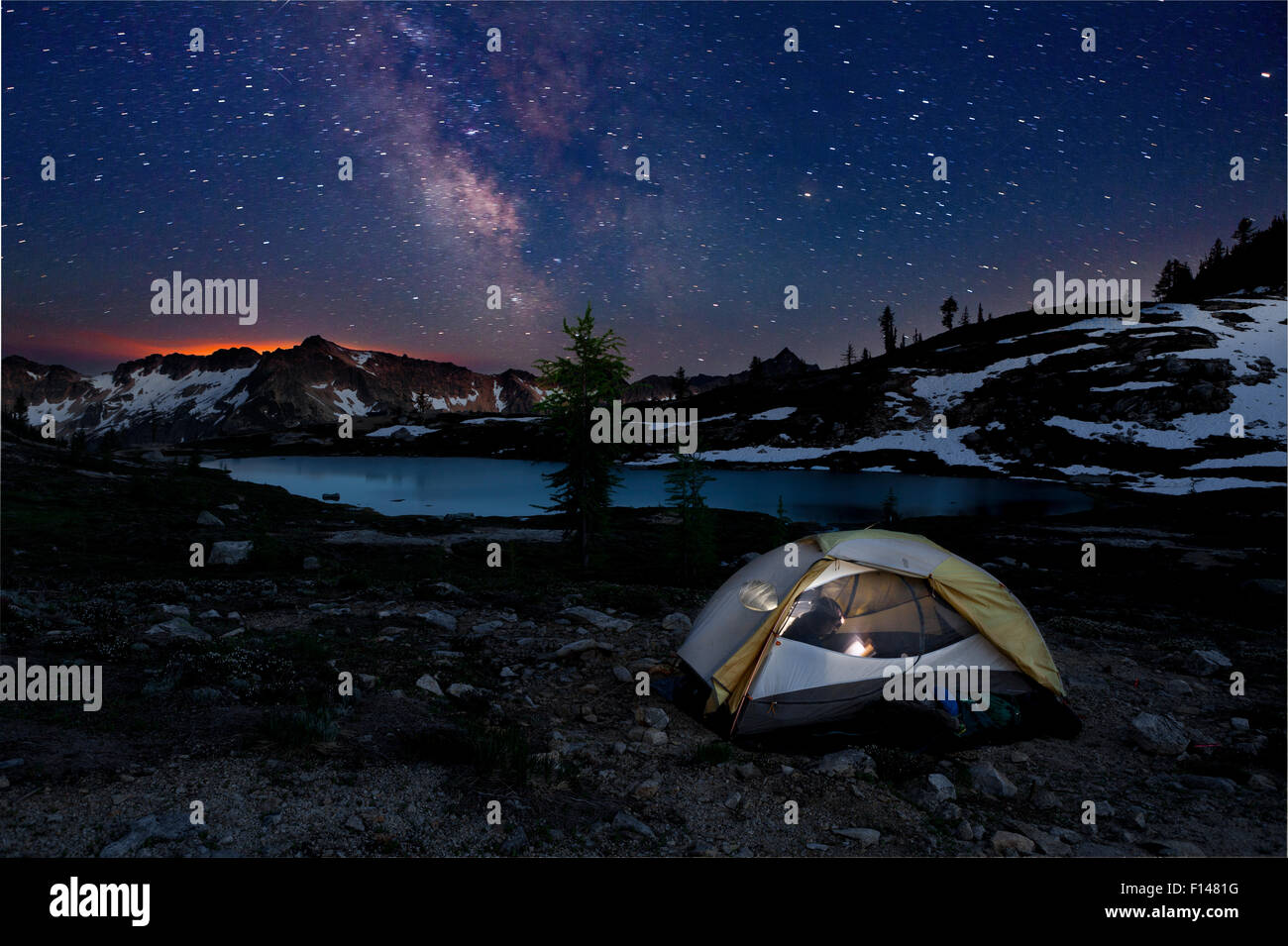 Campingplatz nachts im Schein der Waldbrand am Horizont-Snowy Seen Becken. North-Cascades-Bereich der Okanogan Wenatchee National Forest, Washington, USA, Juli 2014. -Modell veröffentlicht. Stockfoto