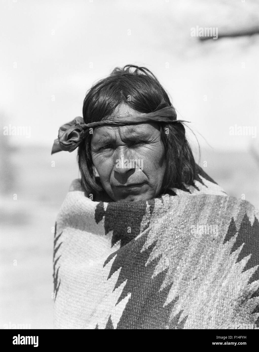 1930ER JAHREN ERNSTHAFTE PORTRAIT INDIANER INDER COCHITI PUEBLO IN HANDGEWEBTEN DECKE BLICK AUF KAMERA NEW MEXICO USA GEWICKELT Stockfoto