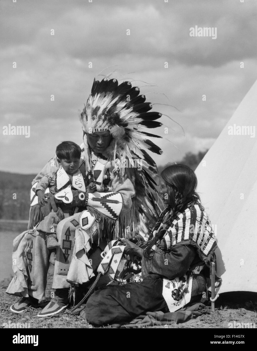 1920ER JAHREN INDIANISCHE FAMILIENVATER FRAU BOY VOLL FEDER KOPFSCHMUCK KOSTÜM STONEY SIOUX STAMMES ALBERTA KANADA Stockfoto