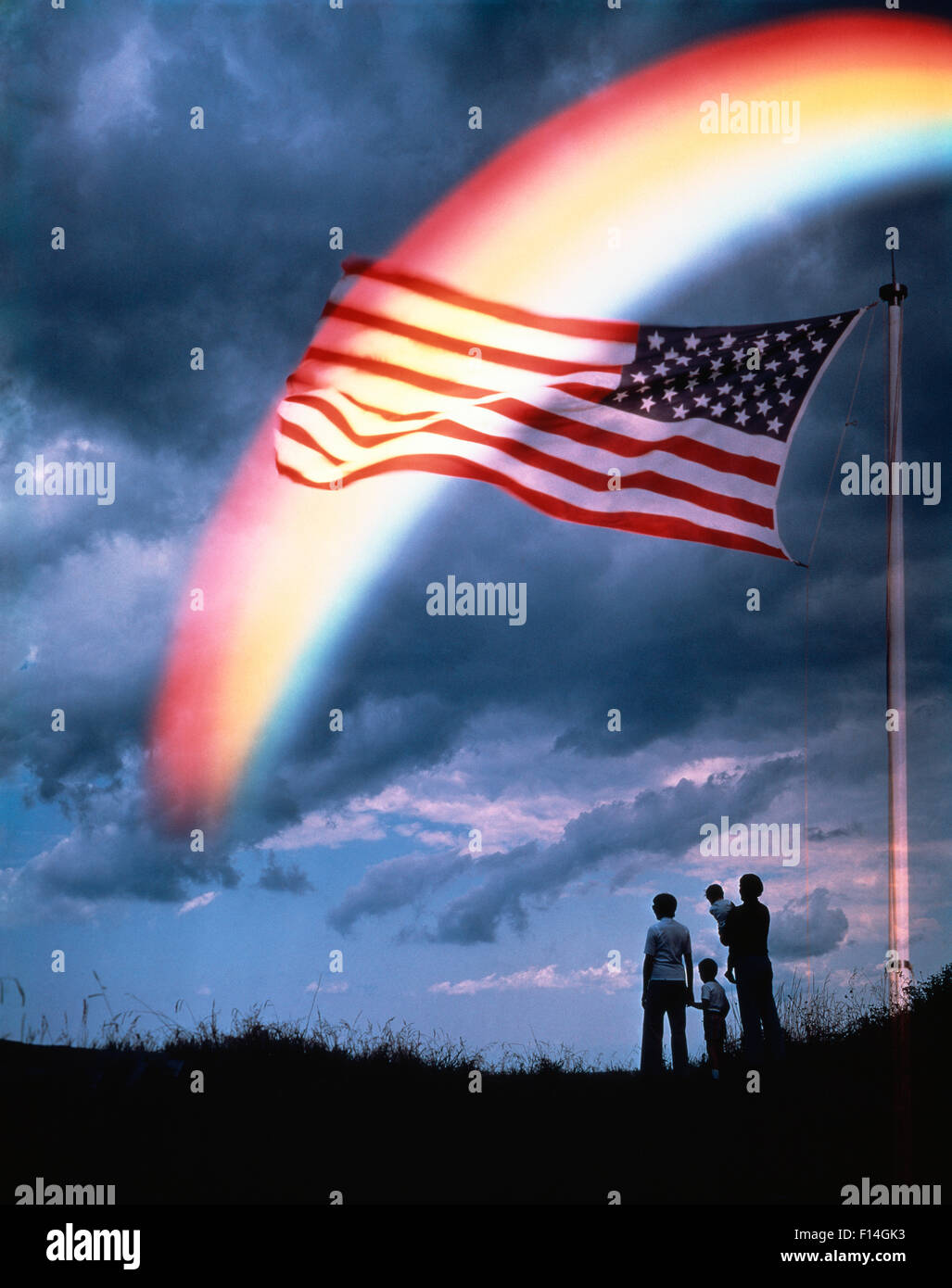 1980ER JAHREN ANONYME SILHOUETTE FAMILIE HILL RAINBOW AMERIKANISCHE FLAGGE PATRIOTISCHEN WOLKEN Stockfoto