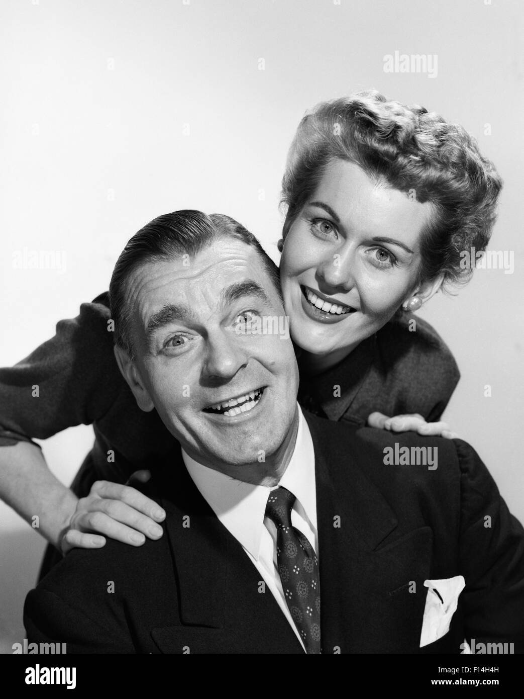 1950ER JAHRE PORTRAIT MANN UND FRAU KÖPFE BERÜHREN EIFRIG GESICHTSAUSDRUCK, BLICK IN DIE KAMERA LÄCHELN Stockfoto