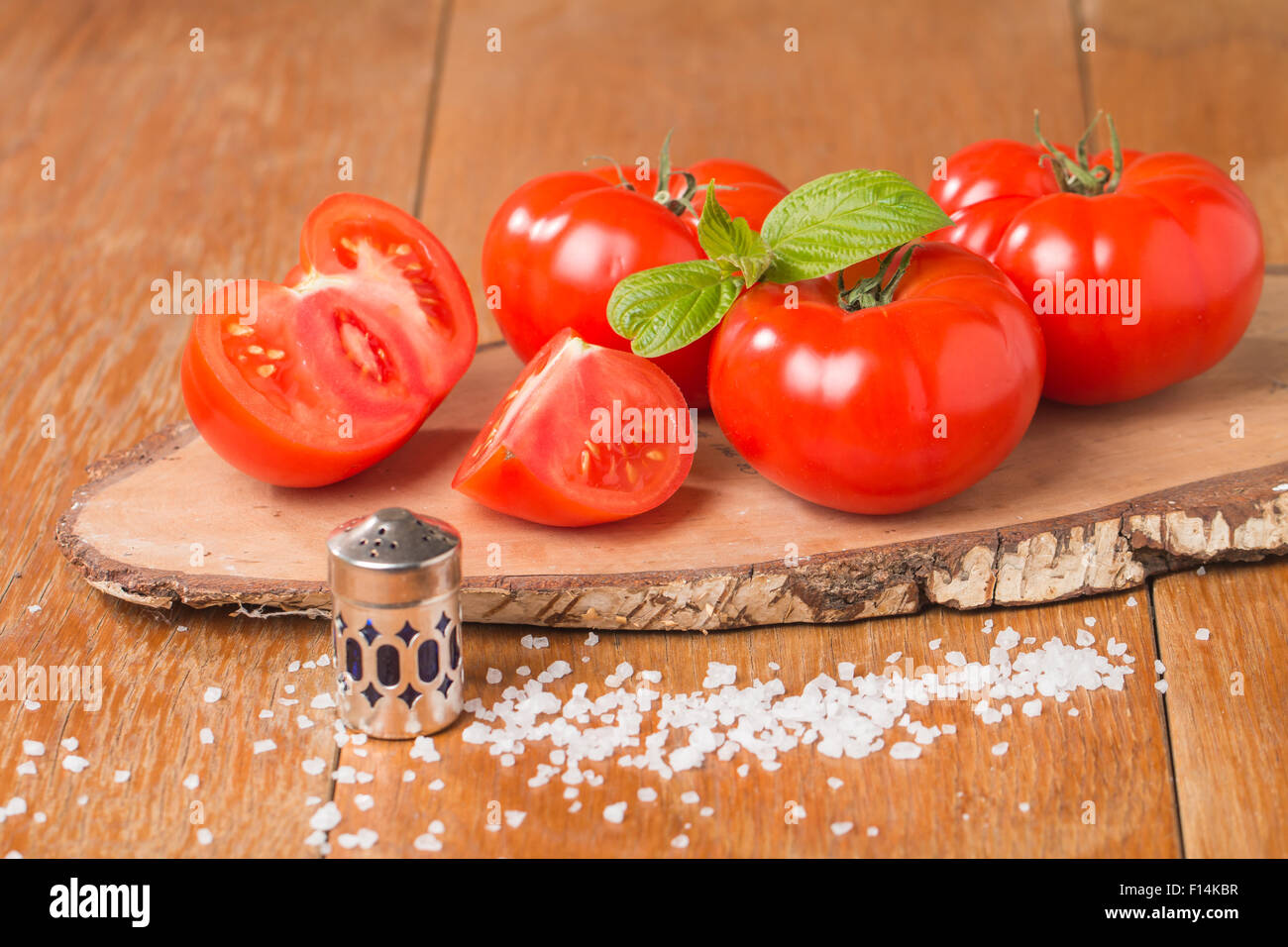 Frische Tomaten mit Salz auf Holztisch Stockfoto