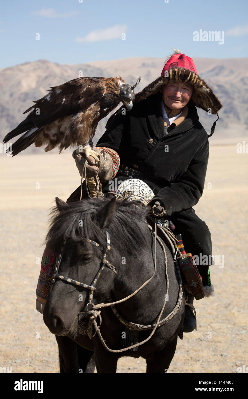 Adler-Jäger montiert auf mongolischen Pferd mit seiner weiblichen Steinadler (Aquila Chrysaetos) Eagle Jäger Festival, in der Nähe von Sagsai, Bayan-Ulgii Aymag, Mongolei. September 2014... Stockfoto