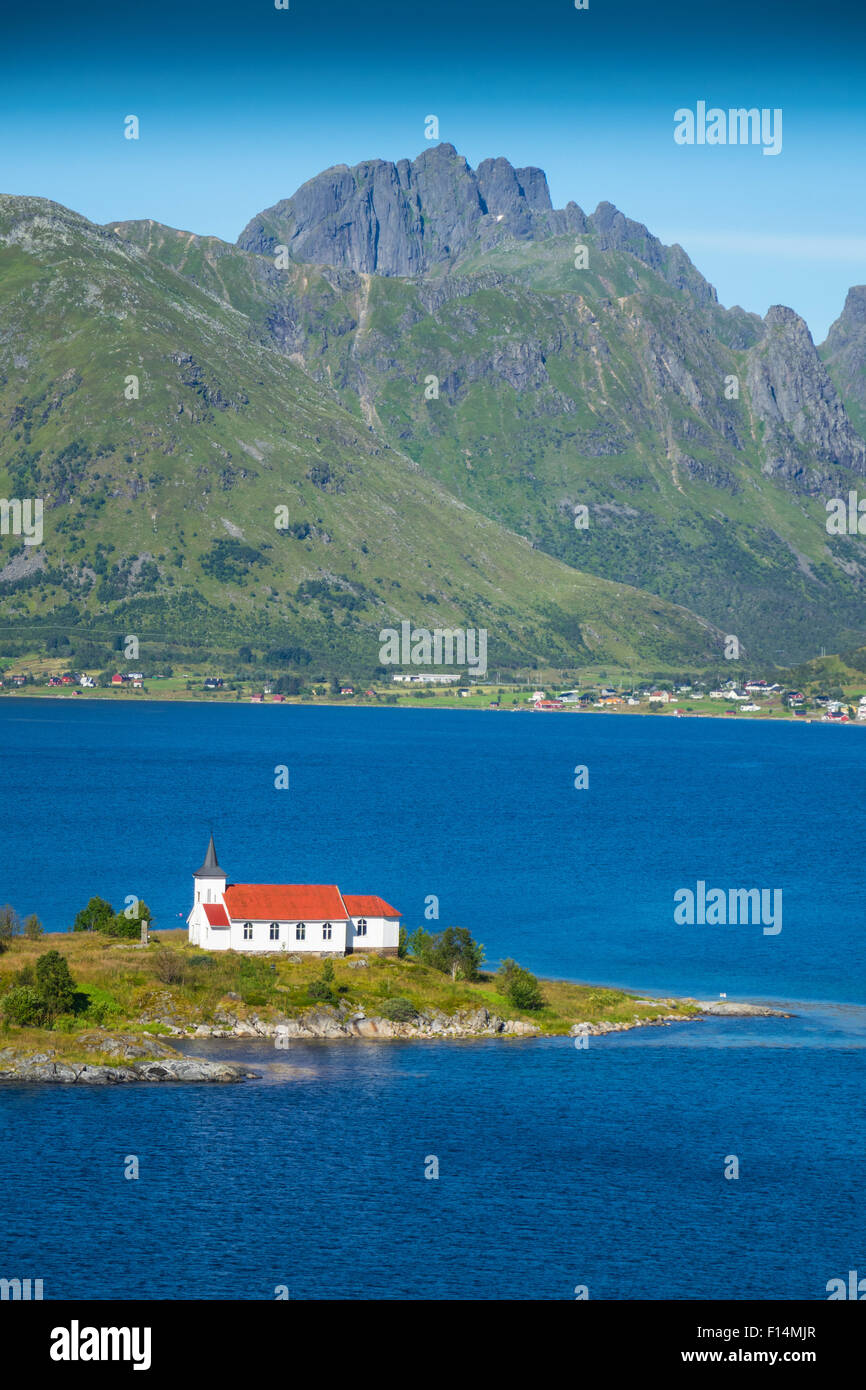 Weiße Kirche mit rotem Dach in den Bergen und Fjord Einstellung, Lofoten, Norwegen Stockfoto