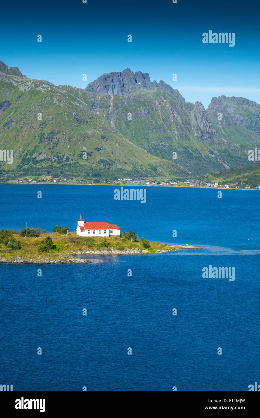 Weiße Kirche mit rotem Dach in den Bergen und Fjord Einstellung, Lofoten, Norwegen Stockfoto