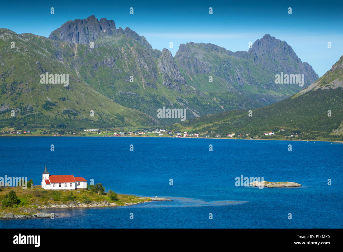 Weiße Kirche mit rotem Dach in den Bergen und Fjord Einstellung, Lofoten, Norwegen Stockfoto