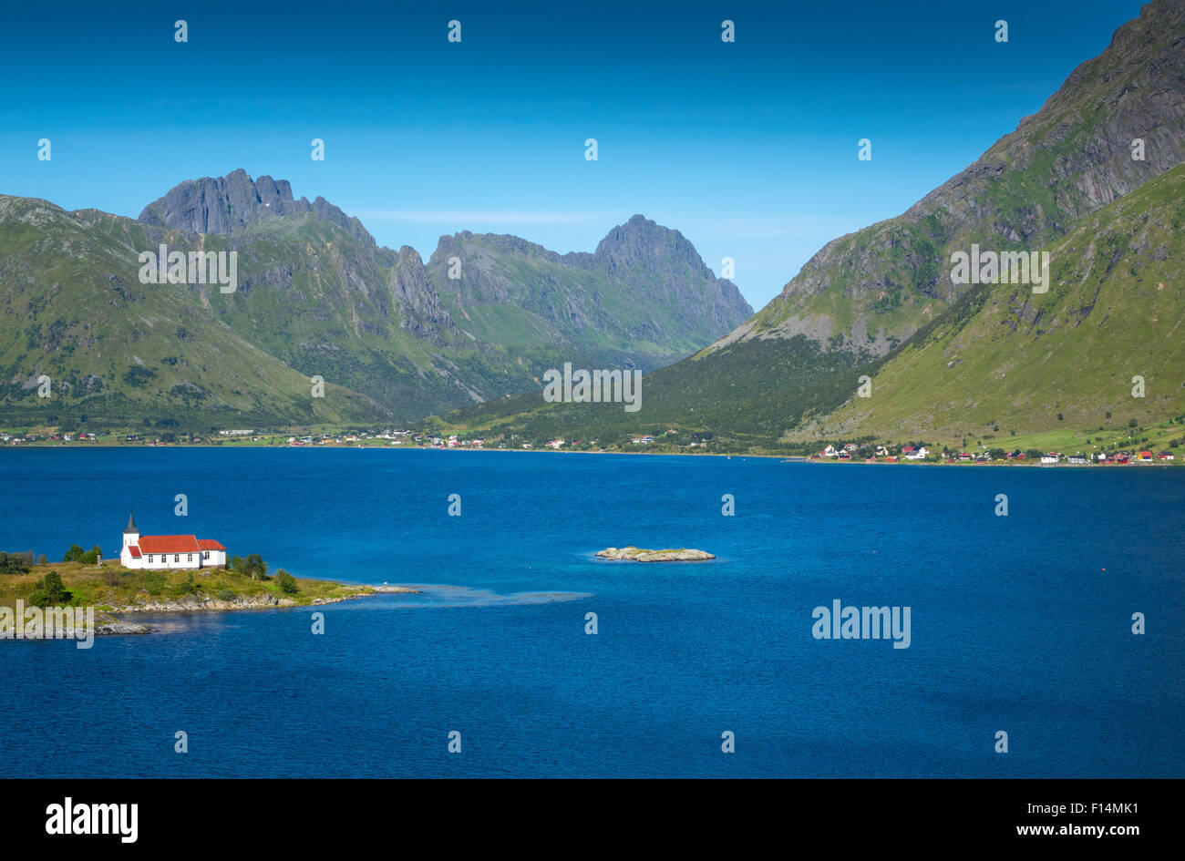 Weiße Kirche mit rotem Dach in den Bergen und Fjord Einstellung, Lofoten, Norwegen Stockfoto