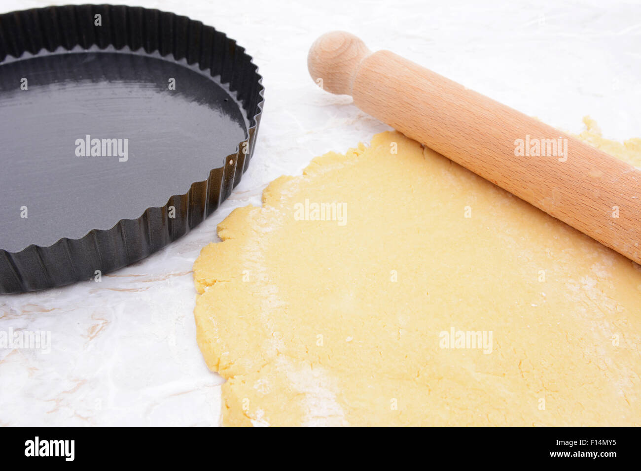 Locker-Talsohle Backform neben Mürbeteig und Nudelholz ausgerollt Stockfoto
