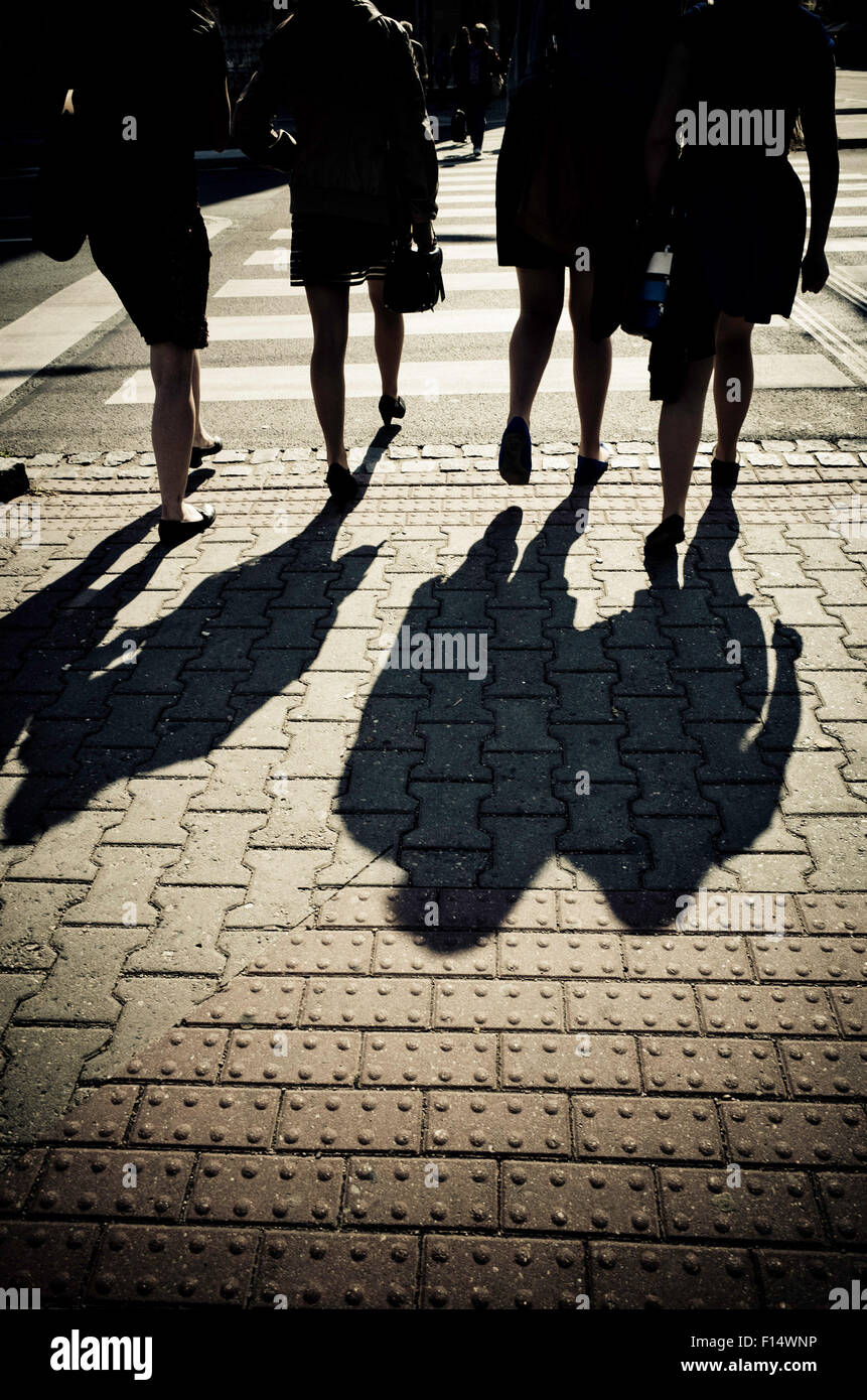 vier Frauen in der Silhouette, die auf der Straße Stockfoto