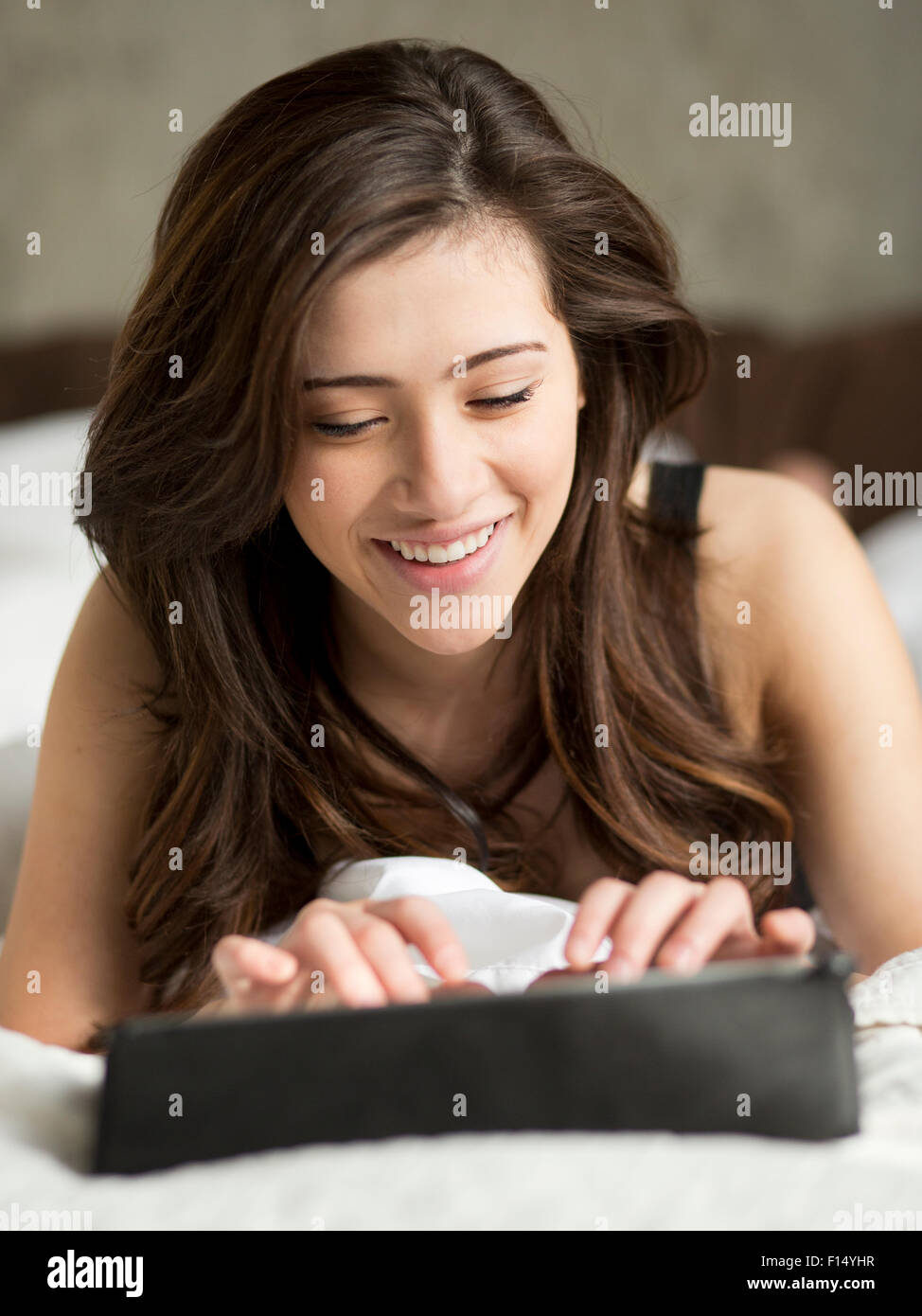 Frau auf Bett mit digital-Tablette Stockfoto