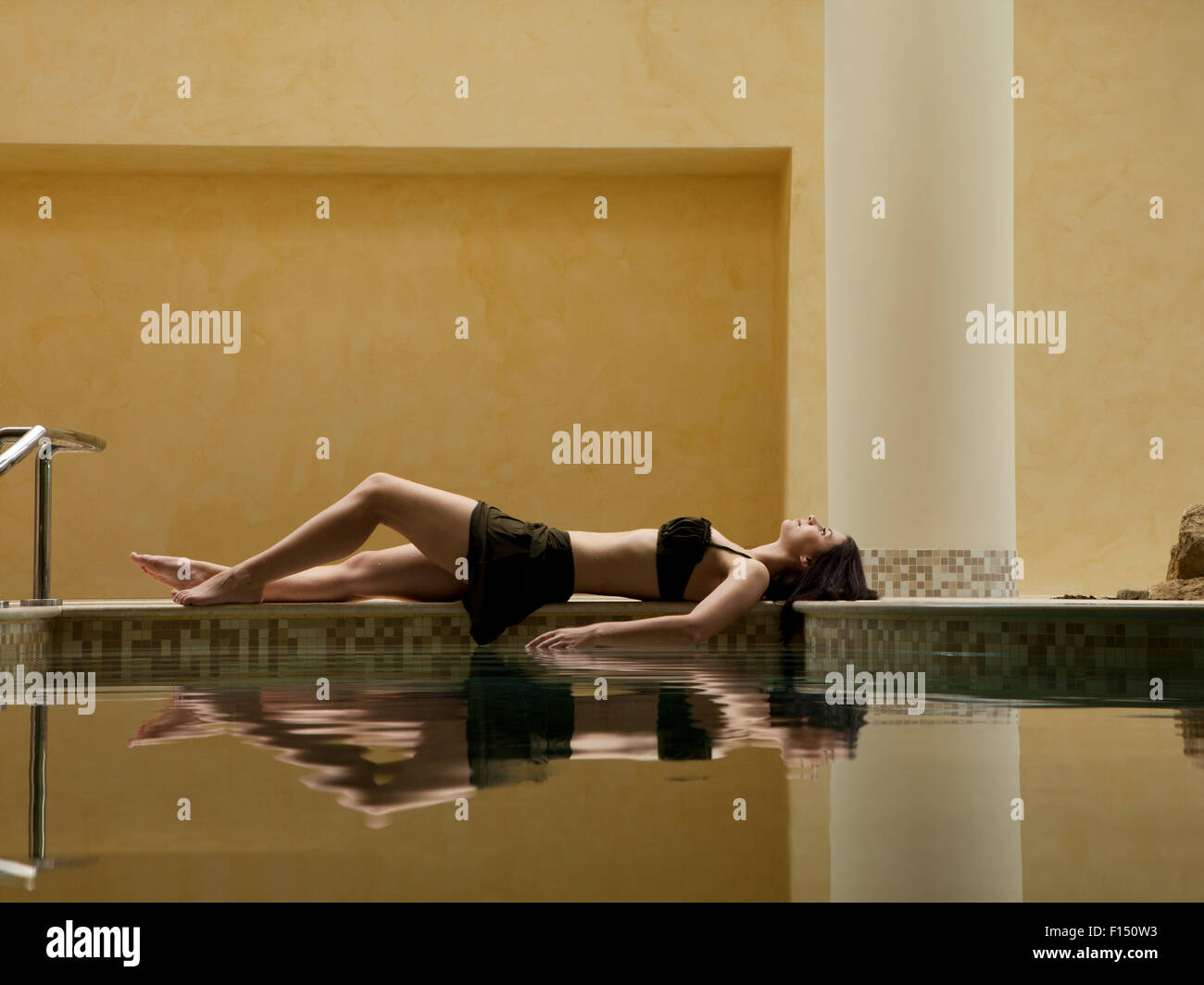 Italien, junge Frau, die am Rand des Swimming Pool entspannen Stockfoto