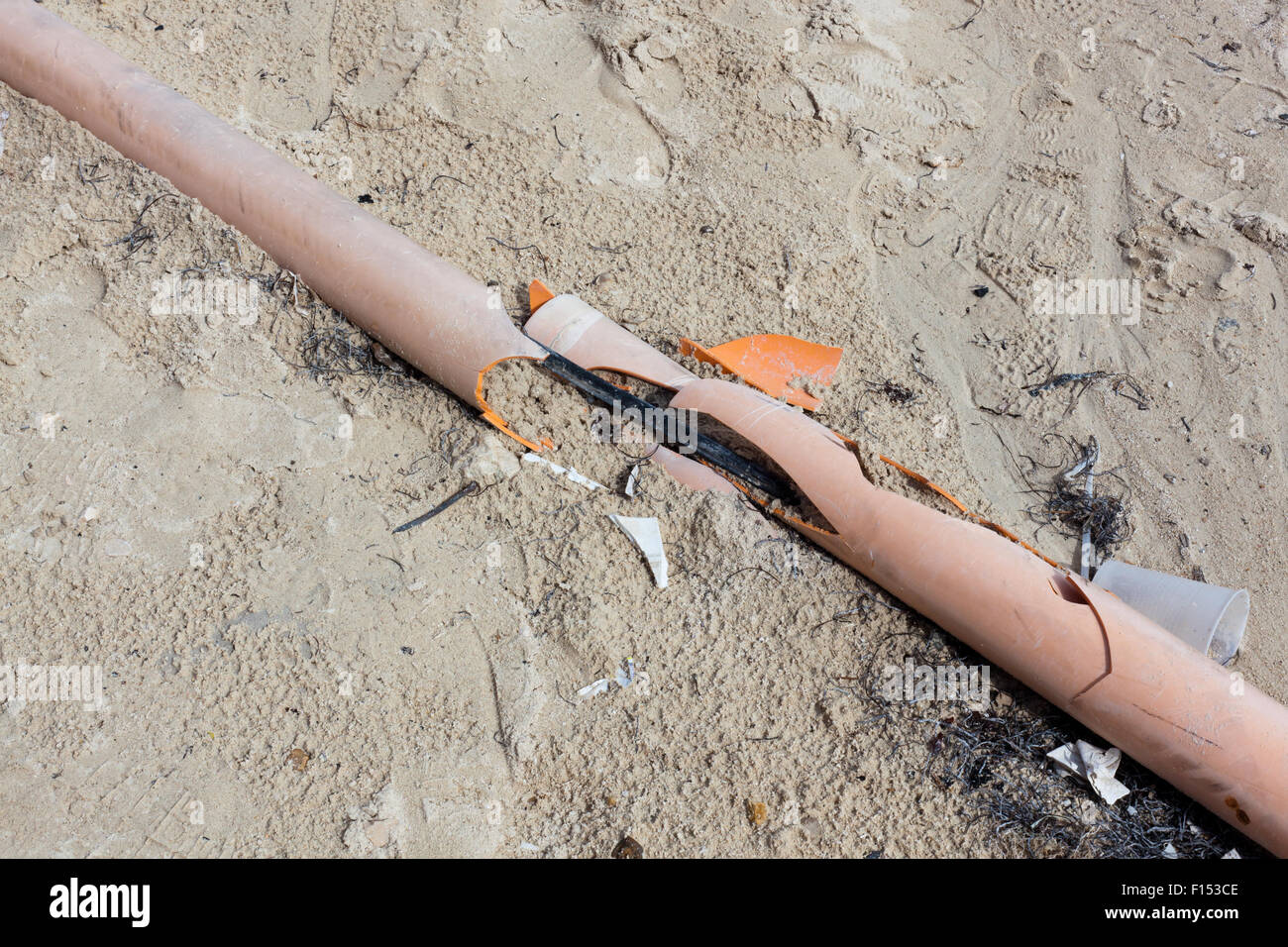 Ein Conduit-Rohr mit Adern durchzogen vom Strand Verkehr wurde aufgebrochen und ist umgeben von Wurf. Stockfoto