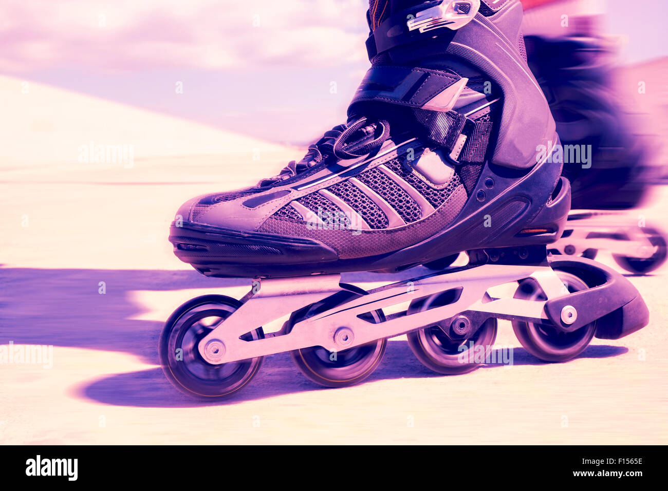 Nahaufnahme von den Füßen eines jungen Mannes Rollerskating mit Inline-Skates, mit einem Filtereffekt Stockfoto