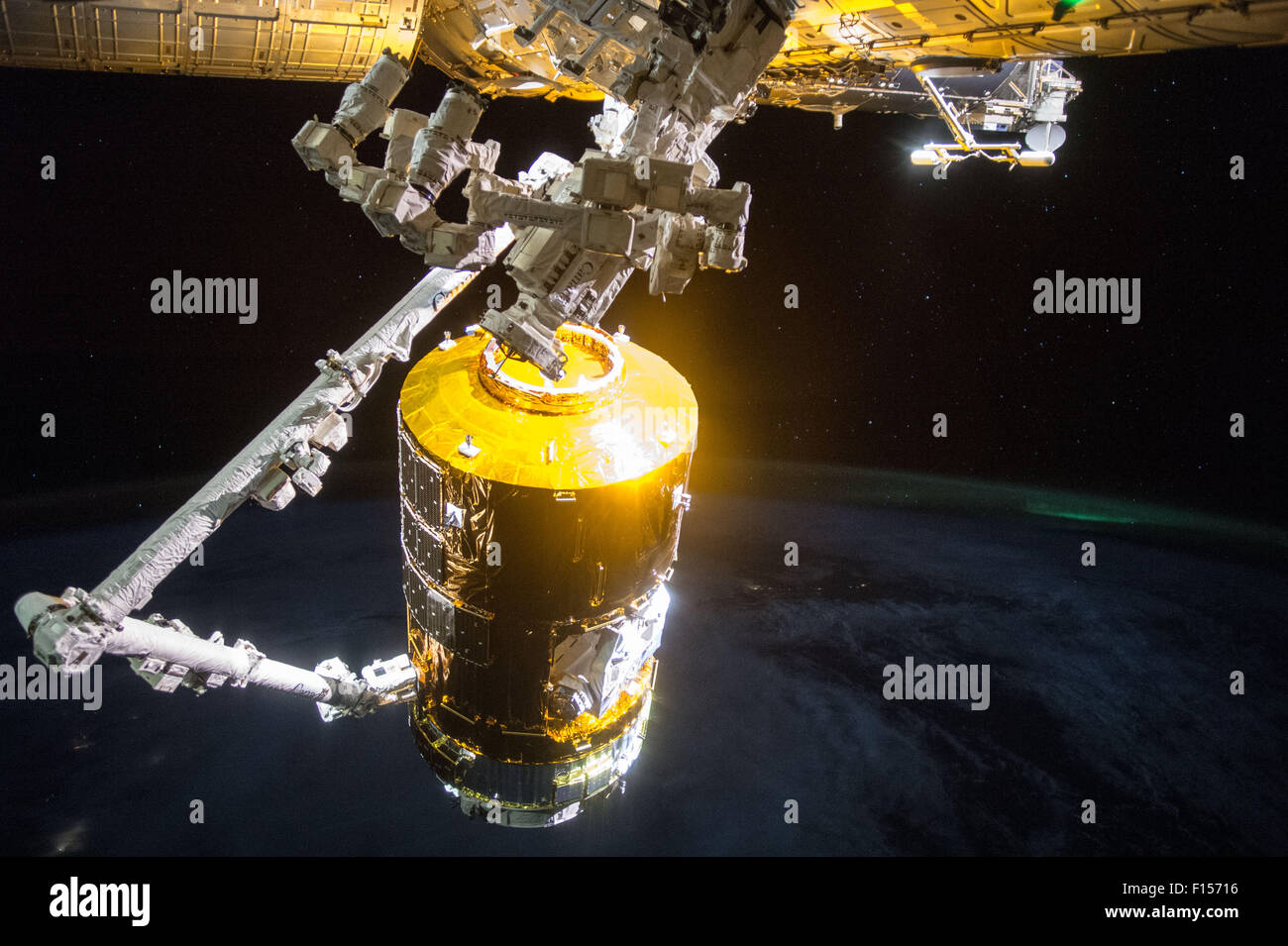 Der Canadarm-2 zieht der Japan Aerospace Exploration Agency Kounotori 5 H-II Transfer Vehicle Cargo Raumsonde in Port auf der internationalen Raumstation ISS 24. August 2015 in der Erdumlaufbahn. Die automatisierte Fracht Handwerk, benannte Kounotori oder Weißstorch, mehr als vier-und-einhälfte Tonnen von Forschung und Versorgung, einschließlich Wasser, Ersatzteile und Experiment Hardware zur ISS durchgeführt. Stockfoto