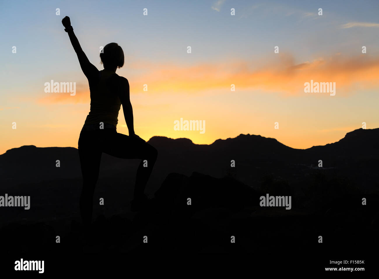 Frau Wandern Silhouette im Sonnenuntergang, Berge und Meer. Weibliche Wanderer, Bergsteiger oder Trailläufer mit ausgestreckten auf Berg Stockfoto