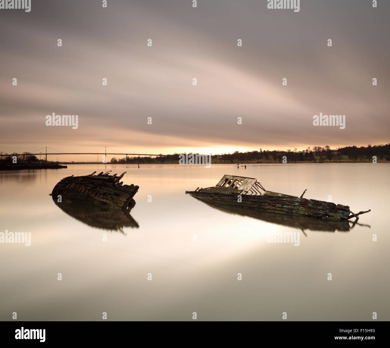 Schiffswracks von Bowling Harbour mit Erskine Bridge im Hintergrund bei Sonnenuntergang Stockfoto