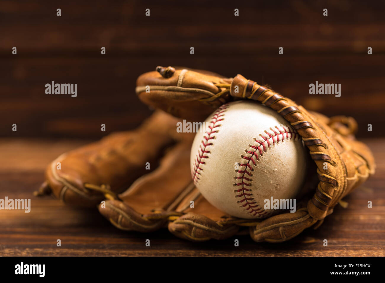 Braun Leder Baseballhandschuh auf einer Holzbank Stockfoto