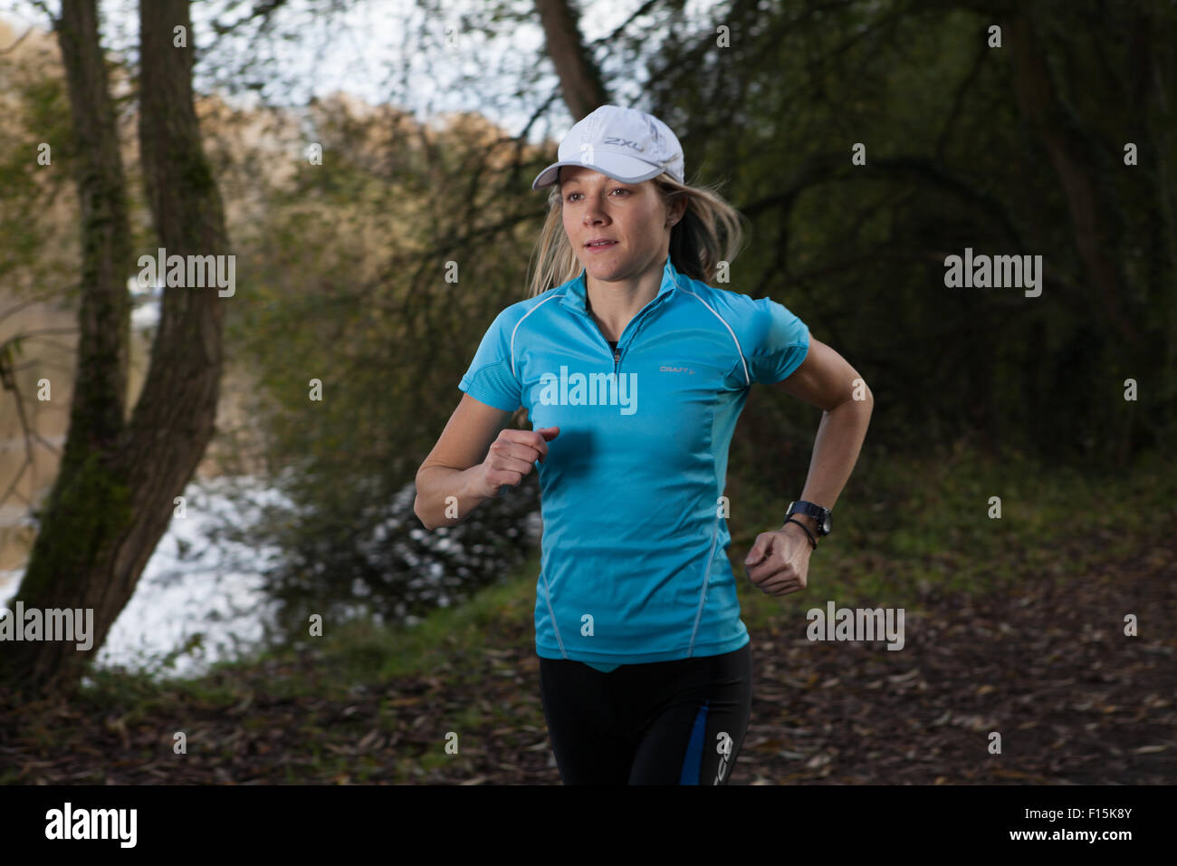 Nahaufnahme der weibliche Läufer tragen Baseball-Cap in ländlicher Umgebung in der Nähe eines Flusses. Stockfoto