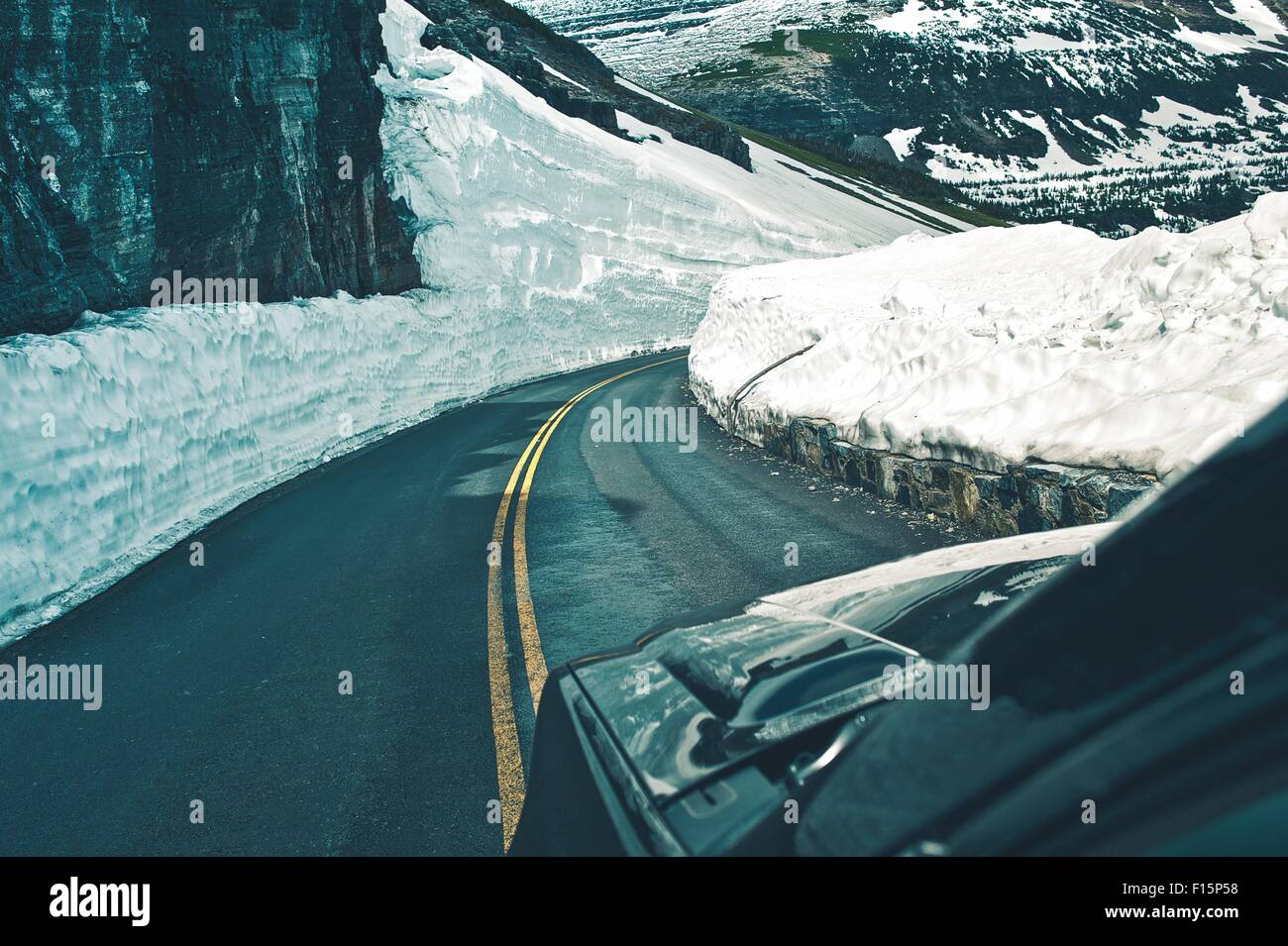 Alpenstraße fahren im Frühjahr. Gefährliche Schneehaufen auf Seiten der Bergstraße. Hohe Berge Road Trip. Stockfoto