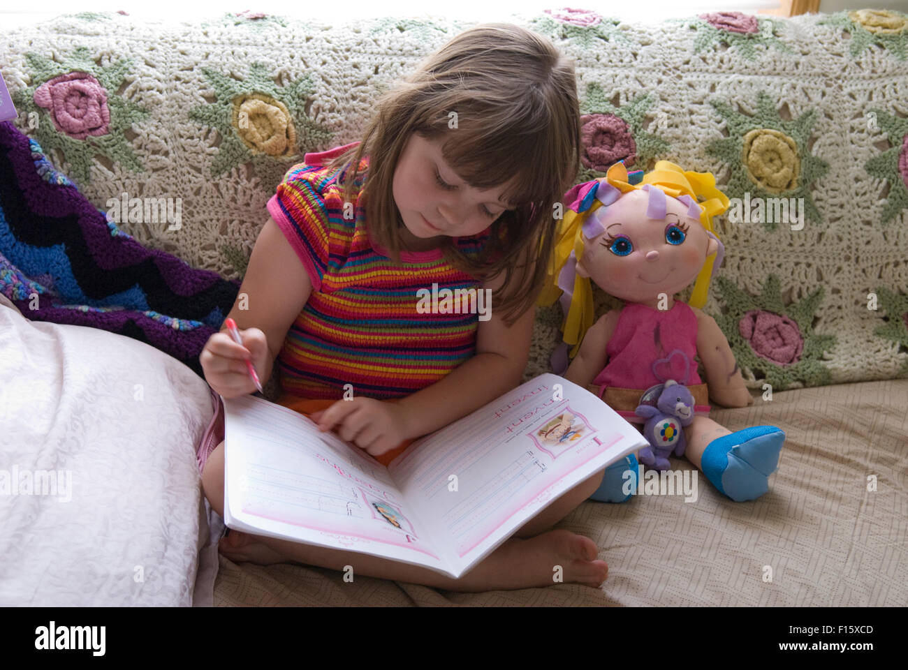 6 Jahre altes Mädchen üben Schreibfähigkeiten in Heimarbeit Buch Stockfoto