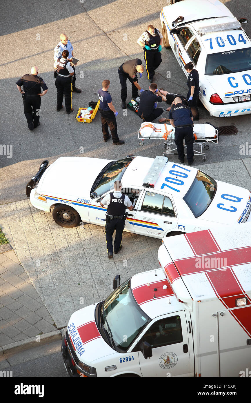 Mediziner und Polizei Herzinfarkt Mann auf der Straße zu helfen. Stockfoto