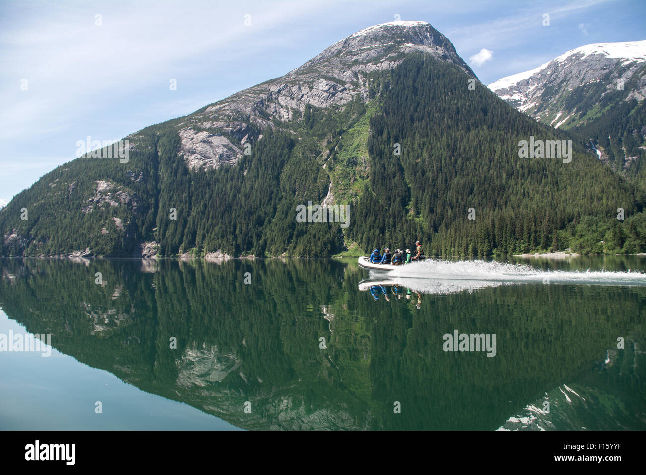 Ein Wildnis-Guide und Touristen reisen auf einen abgelegenen See von Zodiac in der Great Bear Rainforest von British Columbia, Kanada. Stockfoto