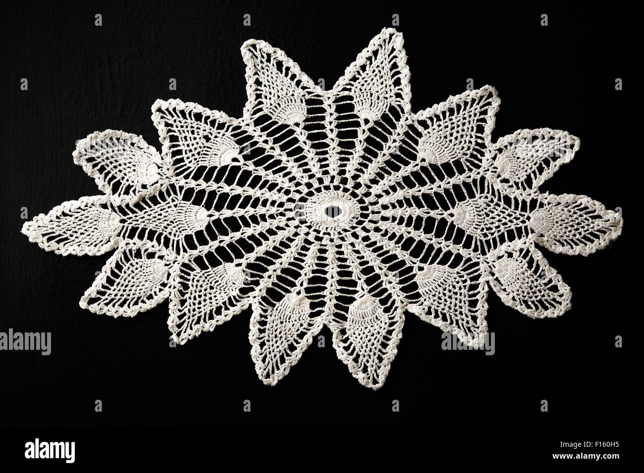 Gehäkelte weißer Spitze dekorative Serviette auf schwarz Stockfoto