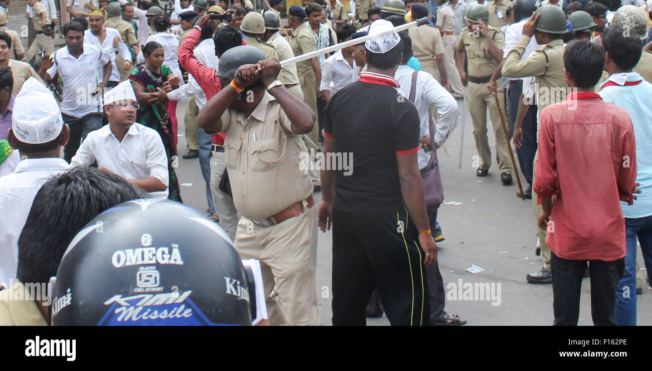 AHMEDABAD, GUJARAT/Indien – 25. August Dienstag 2015 – ist ein Mann von Polizei-Stick in den Straßen von Ahmedabad, Gujarat getroffen. Stockfoto