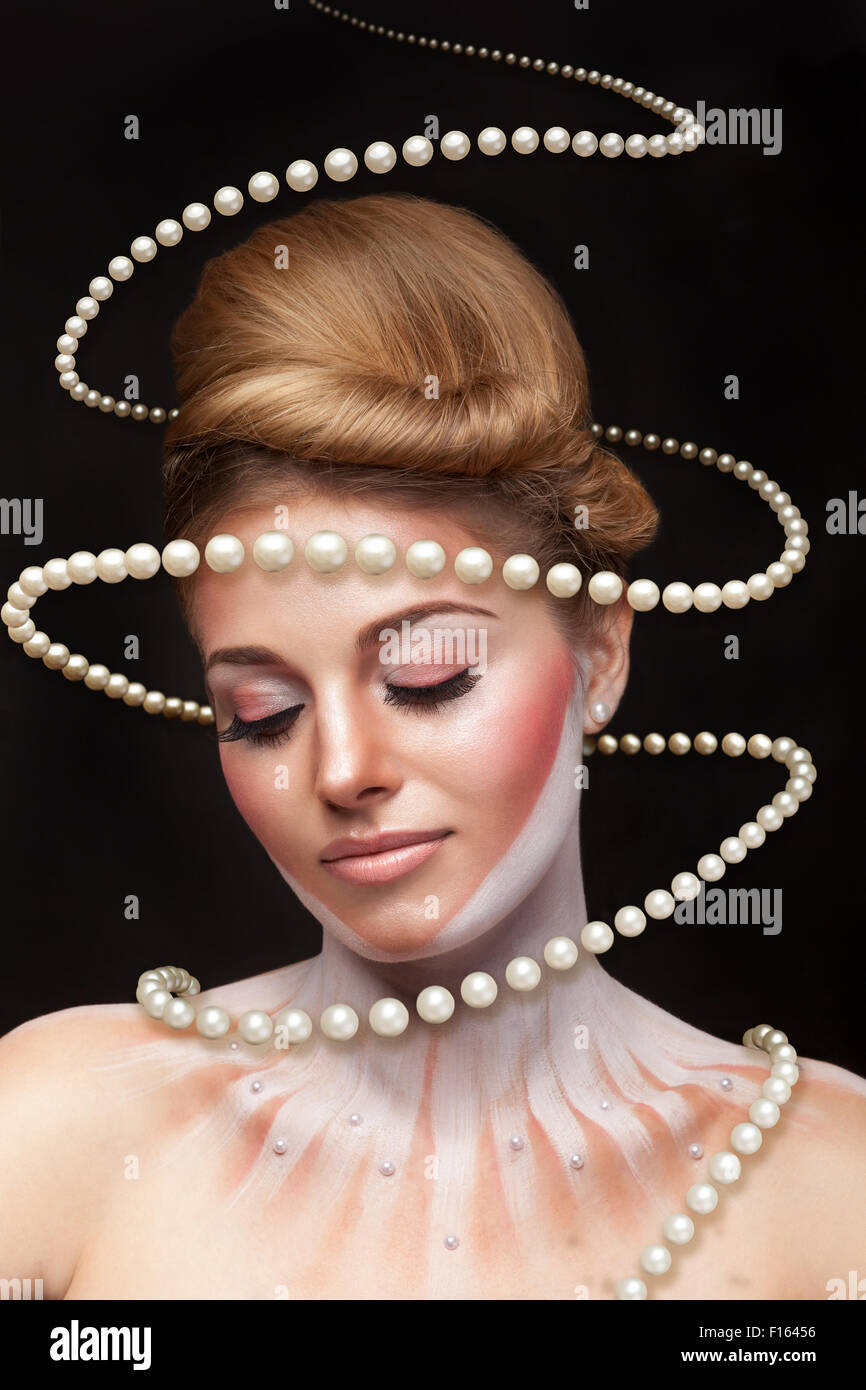 Surreale Kunst-Konzept von Mädchen mit Perlen rund um sie. Studio Aufnahmen. Surrealismus und Concept art Stockfoto