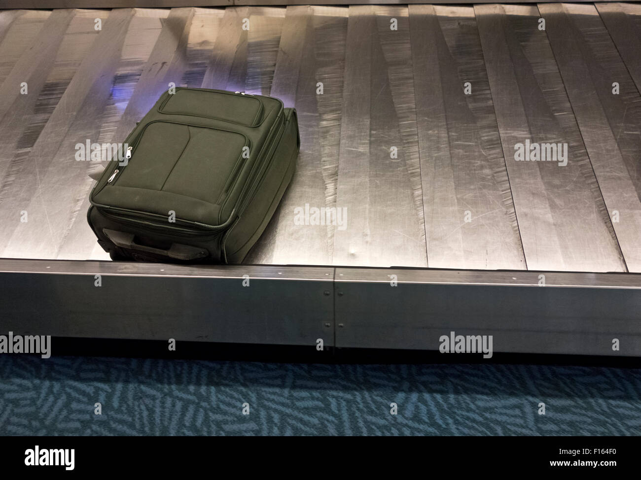 Einsamer Koffer sitzt am Gepäckband am Flughafen.  Verlassene Gepäck. Stockfoto