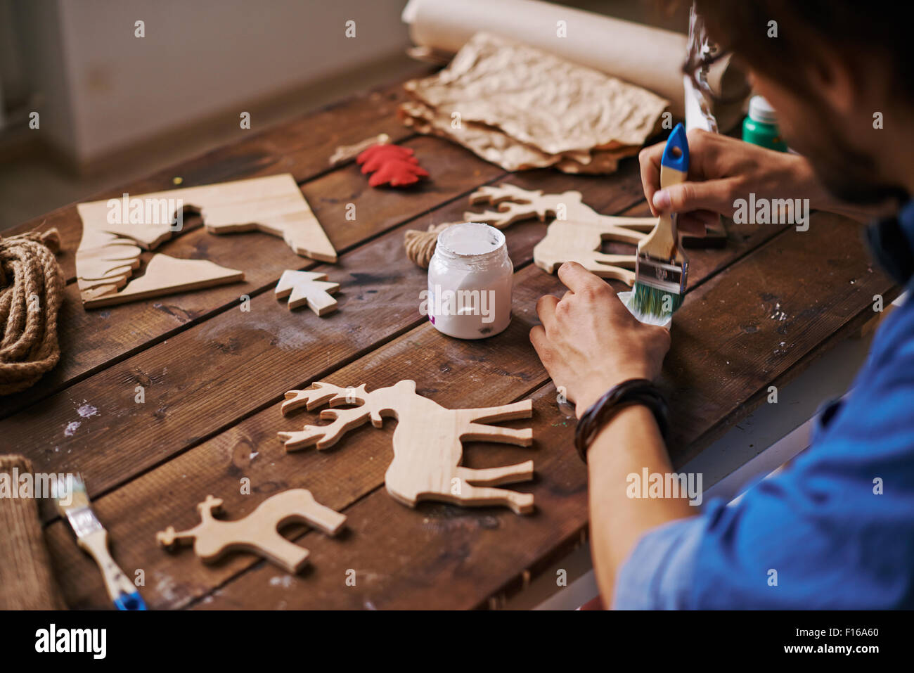 Junge Handwerker mit Paintbrush Xmas Hirsch mit weißen Gouache Malerei Stockfoto