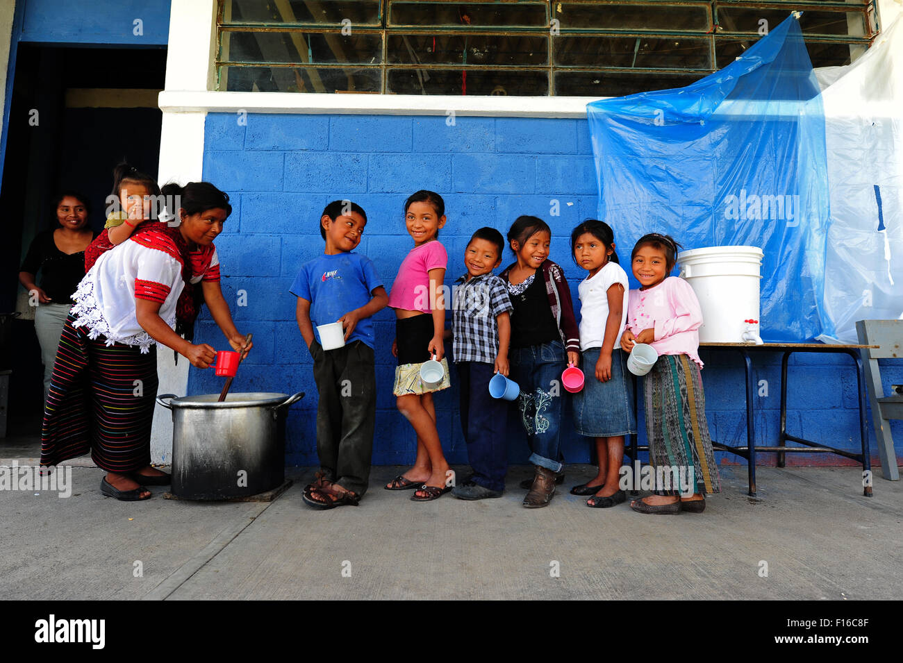 Guatemala, Aguacatan, Schule Mutter (Teresa de Leon Raymundo 32 Jahre mit Rita Aracely de Leon Raymundo 11 Monate) geben Snack an Schulkinder Stockfoto