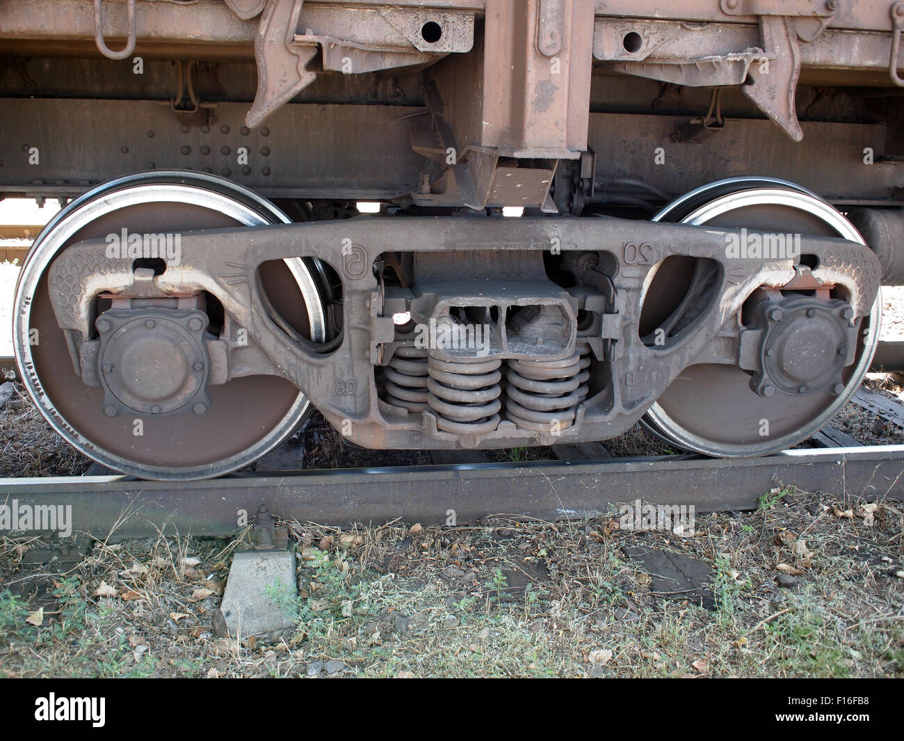 Detail-Nahaufnahme von einem Eisenbahn-Wagen - das Rad, das Unterteil des Autos und der Strecke Stockfoto