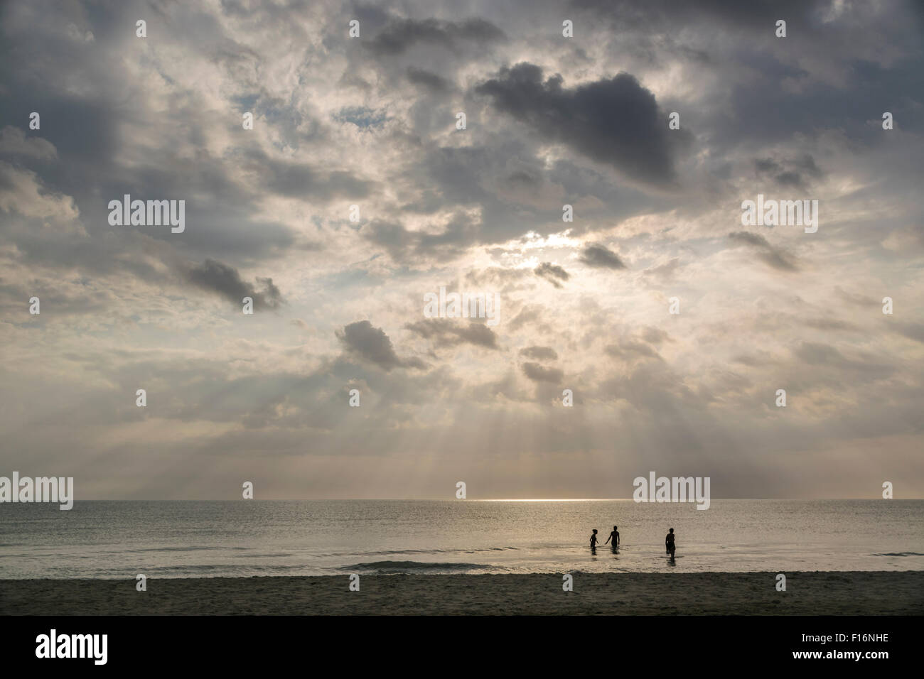 Drei Badende unter einem frühen Abend tauchen im noch warmen Tyrrhenischen Meer. Stockfoto