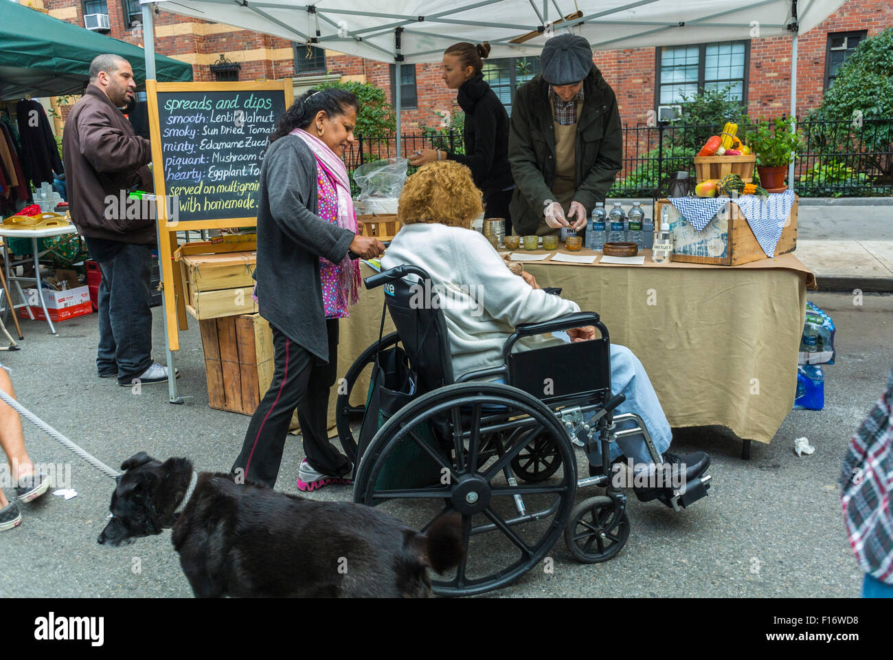 New York City, USA, behinderte ältere Frau im Rollstuhl, besondere Bedürfnisse Shopping in Chelsea Street Flohmarkt, Lebensmittelstand 'Spreads and Dips' Stockfoto
