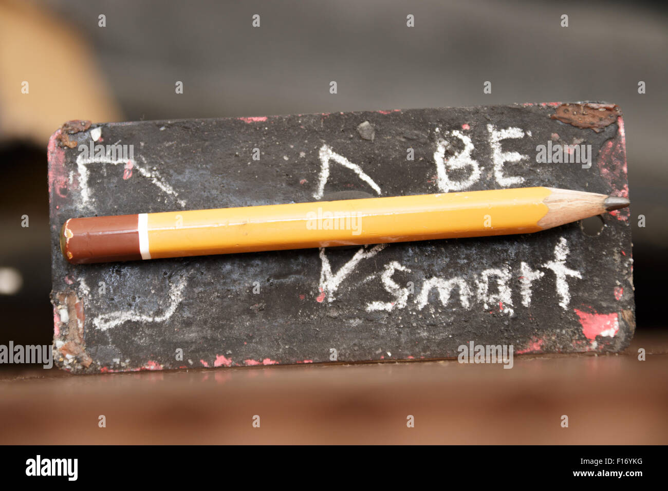 Seien Sie clever. Inschrift in Kreide und Bleistift - Rakete. Das Tag mit der Inschrift auf dem Schreibtisch. Stockfoto
